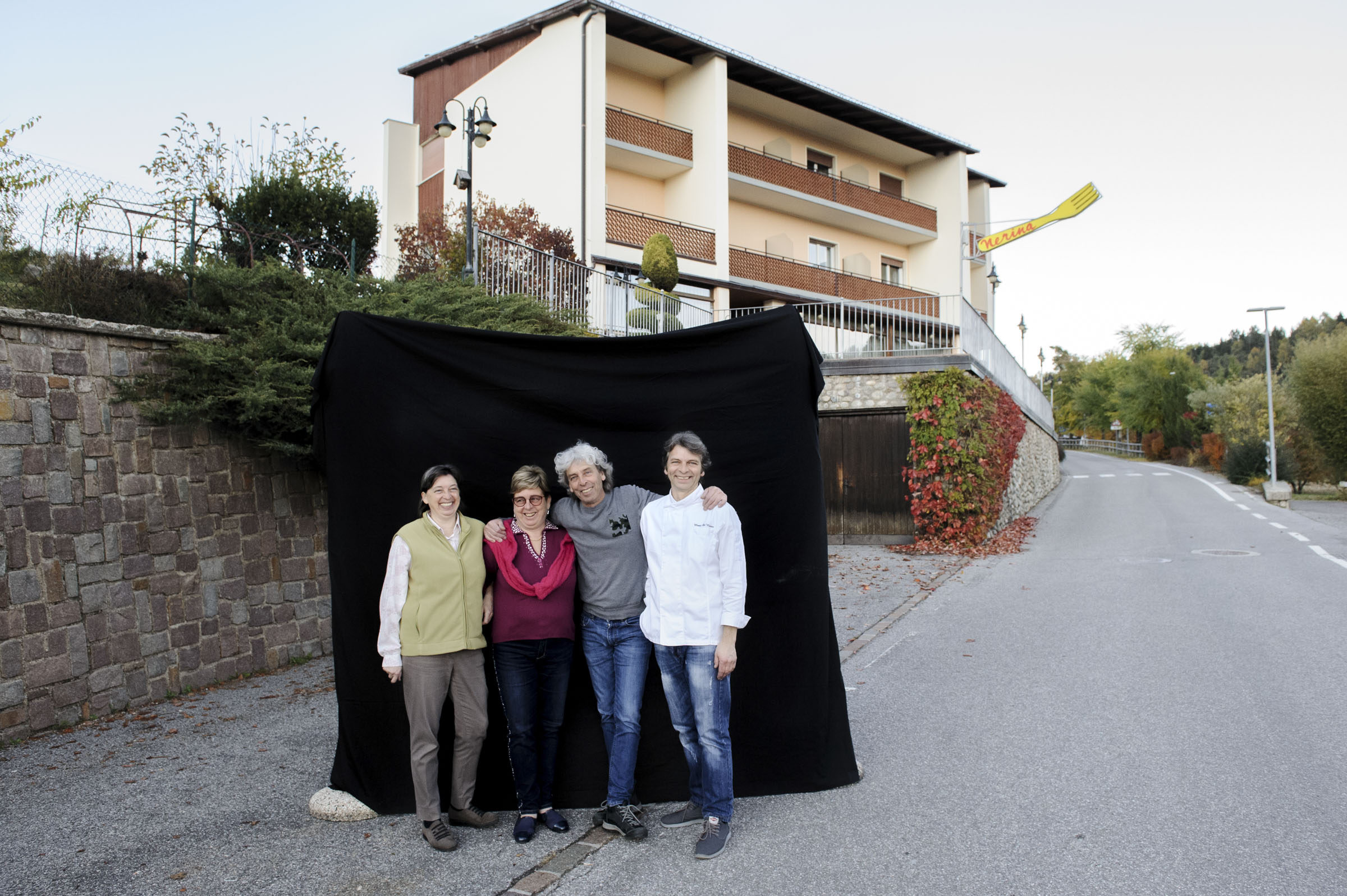 Four people standing in front of a restaurant.