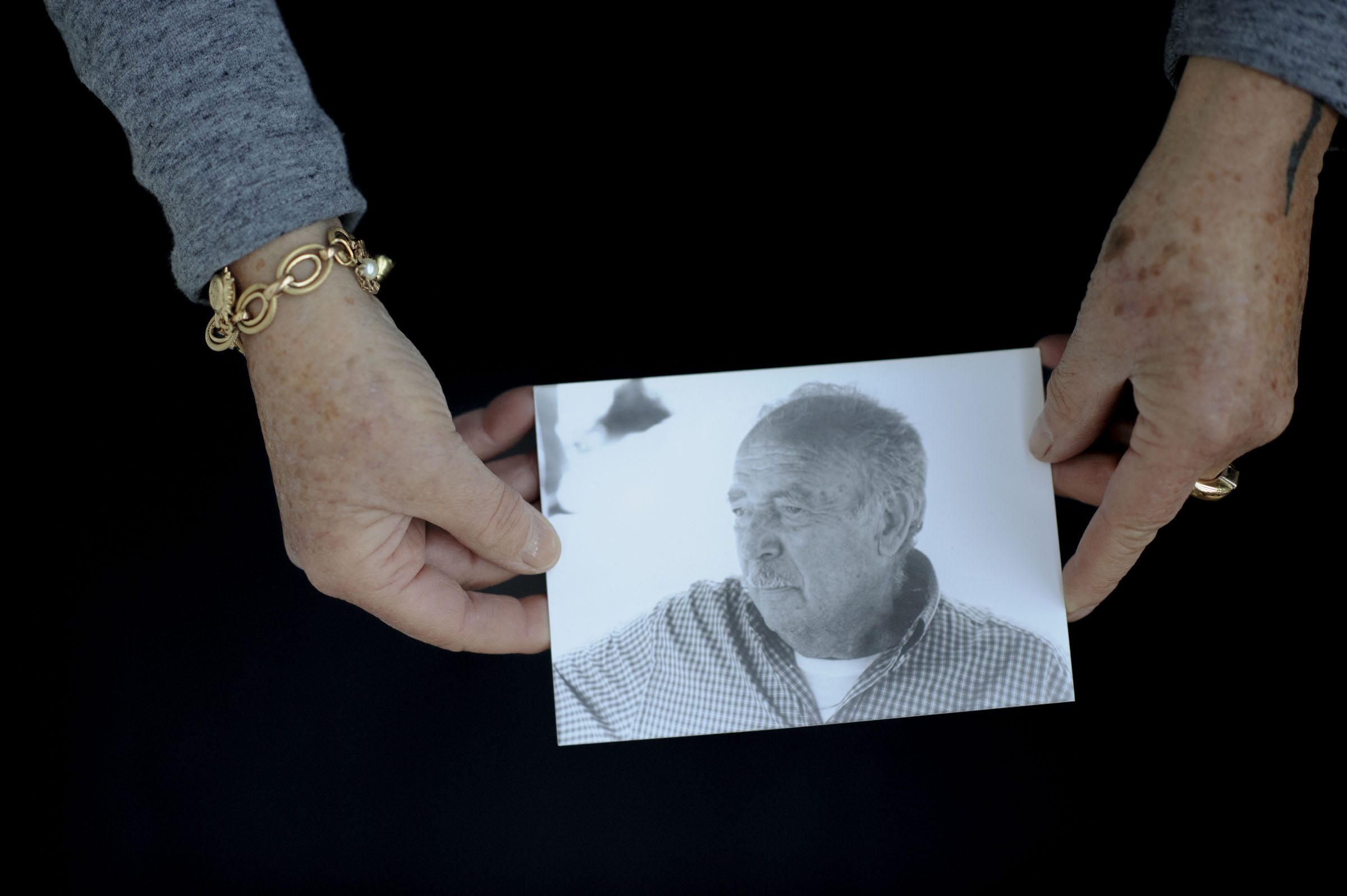 Two hands holding a portrait photo.