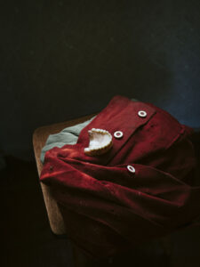Clothing draped over a wooden stool, and a set of dentures.